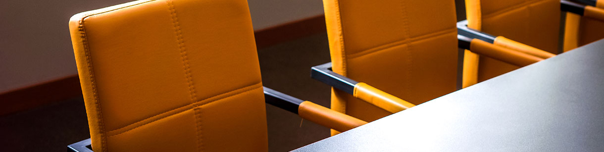 Yellow-orange leather chairs at a meeting table
